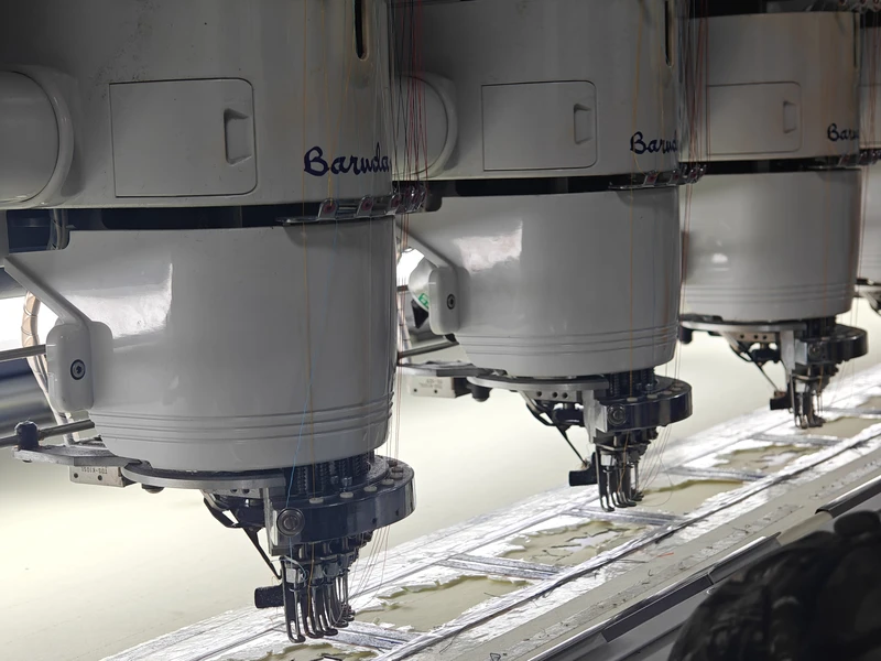 Close view of industrial embroidery machine heads and needles